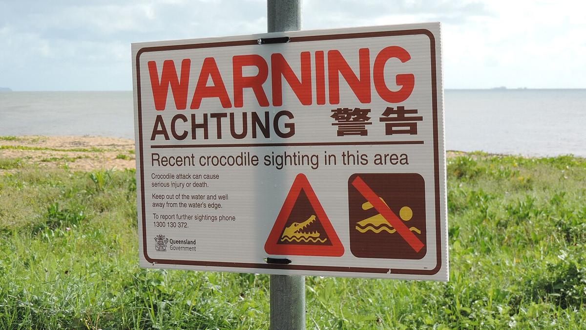 Krokodil-Warnschild mit deutschem Hinweis Achtung